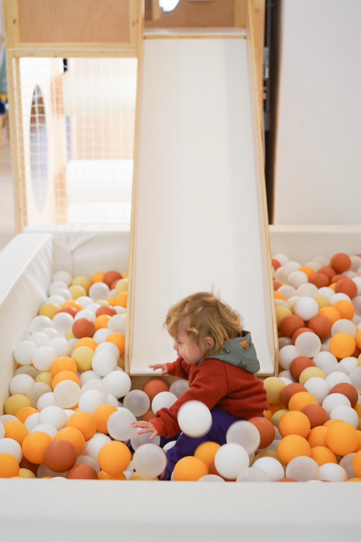 Niño jugando en la piscina de bolas de la ludoteca Tribu House en Poblenou, Barcelona